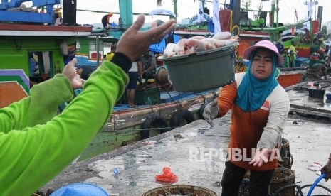 Aktivitas pekerja membongkar muat ikan hasil tangkapan nelayan di Tempat Palelangan Ikan (TPI) Brondong, Lamongan, Jawa Timur, Kamis (6/10)