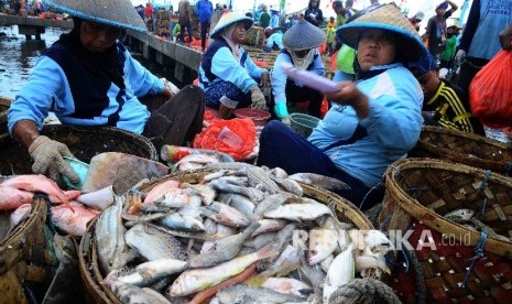 Aktivitas pekerja membongkar muat ikan hasil tangkapan nelayan di Tempat Palelangan Ikan (TPI) Brondong, Lamongan, Jawa Timur, Kamis (6/10)