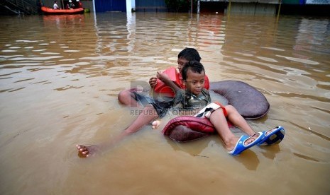 Aktivitas warga di Jalan Abdullah Syafei yang tergenang banjir akibat meluapnya Kali Ciliwung di Kampung Melayu, Jakarta, Sabtu (18/1). (Republika/Prayogi)