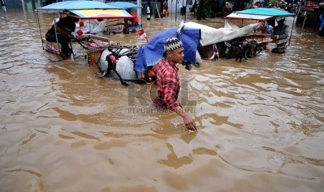 Aktivitas warga di Jalan KH Abdullah Syafei yang tergenang banjir akibat meluapnya Kali Ciliwung di Kampung Melayu, Jakarta, Sabtu (18/1). (Republika/Prayogi)