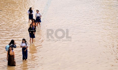 Aktivitas warga di Jalan KH Abdullah Syafei yang tergenang banjir akibat meluapnya Kali Ciliwung di Kampung Melayu, Jakarta, Sabtu (18/1). (Republika/Prayogi)