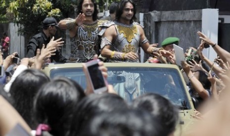 Aktor India pemeran Arjuna dan Yudhistira dalam film serial Mahabharata, Shaheer Sheikh (kiri) dan Rohit Bharadwaj (kanan) menyambut para penggemarnya saat arak-arakan aktor Mahabharata serangkaian acara pentasnya di Denpasar, Bali, Ahad (5/10).