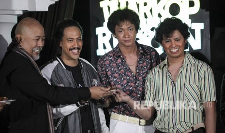 Aktor Indro Warkop menyerahkan potongan tumpeng kepada Randy Danistha (kedua kiri), Adipati Dolken (kedua kanan) dan Aliando Syarief (kanan) pada jumpa pers pemeran baru film Warkop DKI Reborn di Jakarta, Jumat (15/3/2019). 