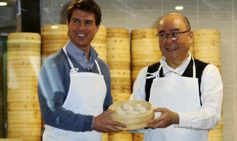 Aktor Tom Cruise berpose bersama Presiden Din Tai Fung Yang Chi-hua dan xiaolongbao, atau dumpling alias pangsit khas restoran tersebut 