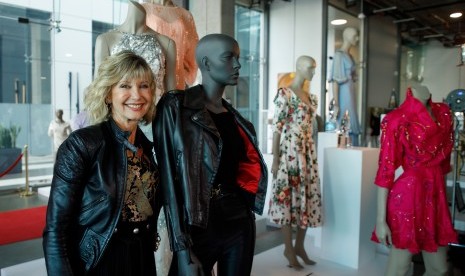 Aktris Olivia Newton-John berpose dengan kostum ikonik yang dikenakannya di film Grease di Julien's Auctions, Beverly Hills, AS.