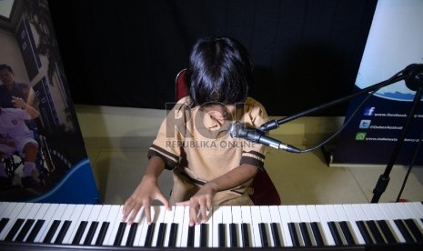 Seorang siswa disabilitas bermain piano 