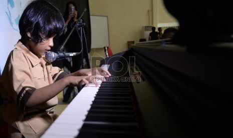 Alafta Hirzi Sadiq (7 tahun) Siswa disabilitas bermain piano sambil bernyanyi di SLB A Pembina, Lebak bulus, Jakarta, Rabu (2/12). 