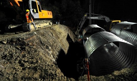 Alat berat bersiap mengerjakan lanjutan perbaikan jembatan sementara Kali Comal, Pemalang, Jawa Tengah, Ahad (20/7). (Republika/ Wihdan)