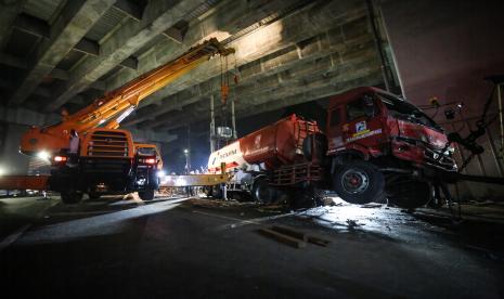 Alat berat digunakan untuk mengevakuasi truk pengangkut BBM yang mengalami kecelakaan maut di Jalan Transyogi, Cibubur, Bekasi, Jawa Barat, Senin (18/7/2022). Truk BBM bermuatan 25 ton Bio Solar tersebut mengalami kecelakaan yang mengakibatkan 10 motor dan 2 mobil rusak serta 10 orang meninggal dunia. 