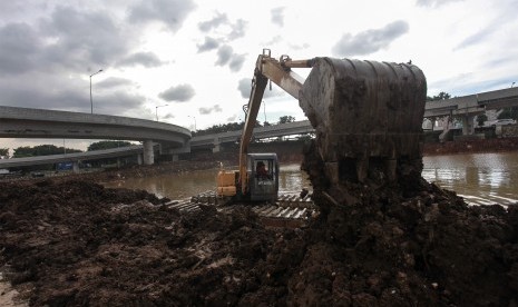 Alat berat dioperasikan mengambil lumpur saat mengerjakan danau buatan. 