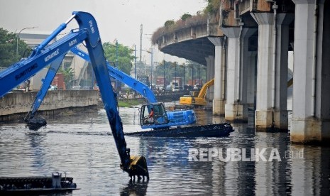 Alat berat dioperasikan untuk mengeruk lumpur yang mengendap di Kali Ancol, Jakarta Utara, Jumat (13/1).