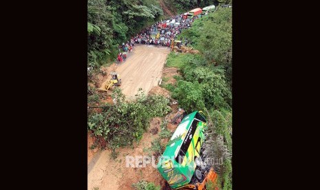 Alat berat membersihkan material longsor yang menghantam tiga unit kendaraan, di Jalur Lintas Padang - Jambi, Panorama II Sitinjau Lauik, Padang, Sumatera Barat, Jumat (14/12/2018).