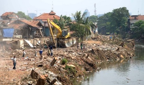 Alat berat membersihkan puing rumah usai pembongkaran paksa, Kampung Pulo, Jakarta, Ahad (23/8). (Republika/WIhdan)