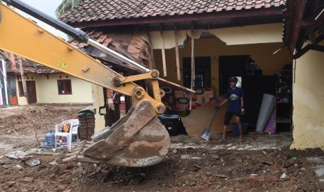 Alat berat membersihkan puing yang hancur akibat tsunami.