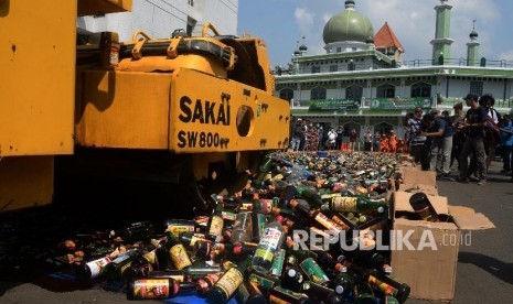 Alat berat menggilas puluhan ribu botol minuman keras (miras) saat pemusnahan di halaman Polres Metro Jakarta Selatan.