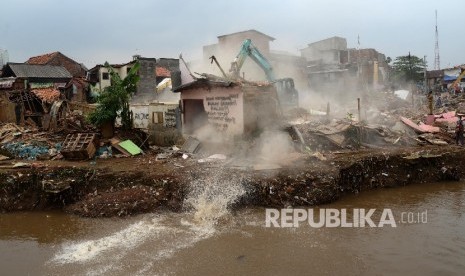 Alat berat menghancurkan bangunan tempat tinggal yang berada di pinggiran sungai Ciliwung kawasan Bukit Duri, Jakarta, Selasa (12/1).