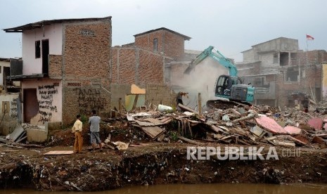 Alat berat menghancurkan bangunan tempat tinggal yang berada di pinggiran sungai Ciliwung kawasan Bukit Duri, Jakarta, Selasa (12/1).