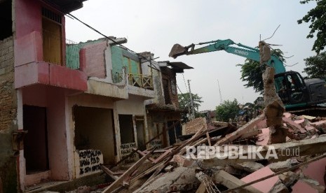 Alat berat menghancurkan bangunan tempat tinggal yang berada di pinggiran sungai Ciliwung kawasan Bukit Duri, Jakarta, Selasa (12/1).