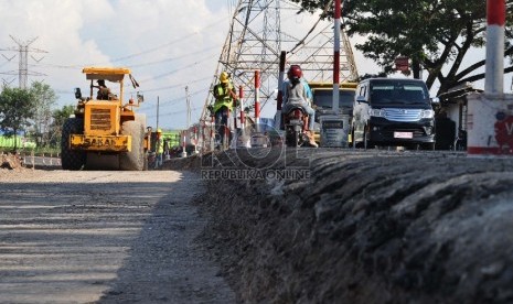 Alat berat meratakan tanah saat dilakukan pelebaran jalur Pantura, Merak,Banten, Kamis (28/5).