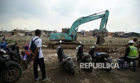 Alat berat meratakan tanah sebagai tahap awal normalisasi di Bantaran kali Ciliwung, Bukit Duri, Jakarta, Selasa (4/10).