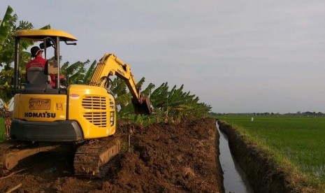 Alat berat sedang meratakan tanah untuk pertanian