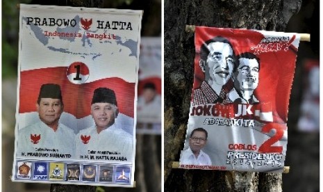 Alat peraga kampanye (APK) bergambar dua pasangan Capres-Cawapres, Prabowo-Hatta (atas) dan Jokowi-JK (bawah), terpasang di pohon, di Semarang, Jateng, Rabu (2/7). 