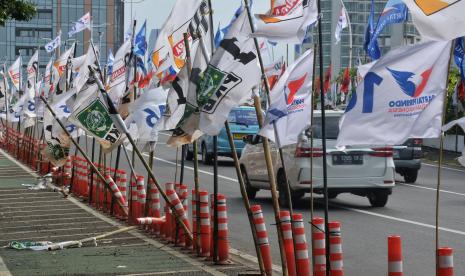 Alat peraga kampanye (APK) pemilu 2024 terpasang di pembatas jalur sepeda (stick cone) di kawasan Menteng, Jakarta, Selasa (9/1/2024).