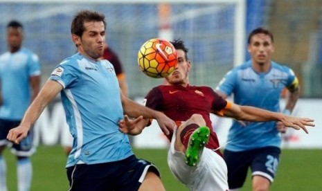 Alessandro Florenzi (merah) berebut bola dengan pemain Lazio Senad Lulic.