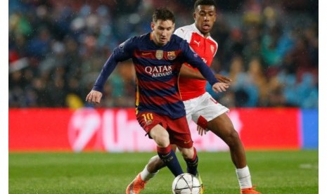 Alex Iwobi (belakang) menjaga pergerakan Lionel Messi.