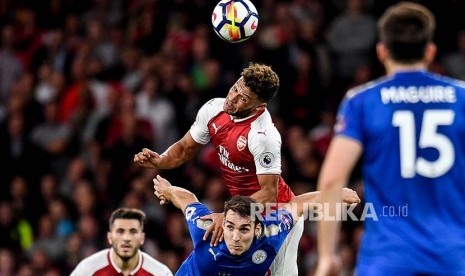 Alex Oxlade-Chamberlain (atas) dan Matty James (bawah) berduel di udara pada pertandingan perdana English Premire League antara Arsenal melawan Leicester City di London, Sabtu (11/8).