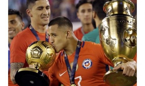 Alexis Sanchez mencium trofi pemain terbaik Copa America Centenario 2016.