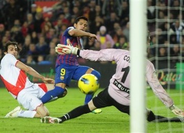  Alexis Sanchez (tengah), striker Barcelona asal Chile, menjebol jala kiper Rayo Vallecano, David Cobeno, di laga La Liga Spanyol di Camp Nou, Barcelona, Selasa (29/11) 