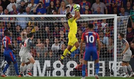 Alisson (kuning) membuat penyelamatan saat Liverpool menghadapi Crystal palace, Selasa (21/8) dini hari WIB.