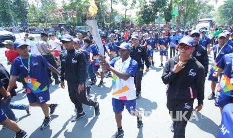 Altlet Timnas sepak bola era 2000-an Alexander Pulalo membawa obor Asian Games di Jalan Diponegoro, Kota Bandung, Sabtu (11/8).