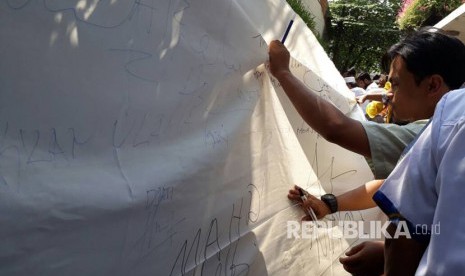 Alumni Bela Islam 212 menandatangani petisi di atas kain sepanjang 1 km untuk mendukung Komnas HAM mengusut pelaku pelanggaran HAM terhadap ulama dan aktivis di Komnas HAM, Jumat (12/5). 