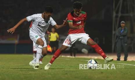 Amirudin Bagus Kahfi (kanan) menggiring bola dikawal pesepak bola Timor Leste U-16 Juvito Moniz (kiri). 