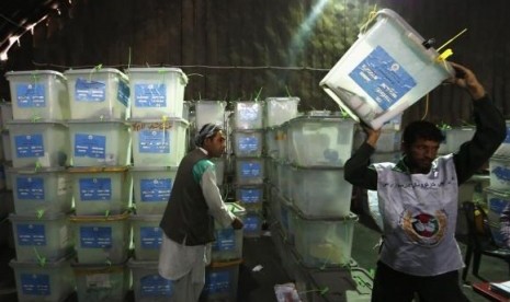 An Afghan election worker carries a ballot box to be counted for an audit of the presidential run-off in Kabul August 27, 2014.