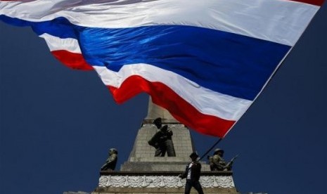 An anti-government protester waves a Thai national flag at Victory Monument in central of Bangkok January 13, 2014.