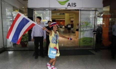 An anti-government protester waves a Thai national flag during a rally at the Shinawatra building in central Bangkok March 10, 2014.