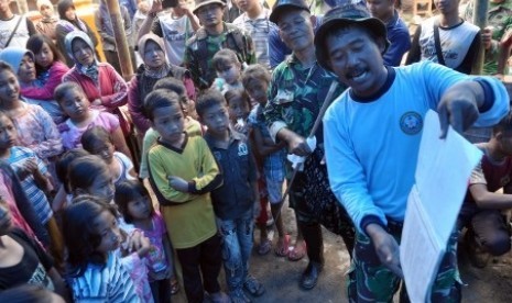 An Indonesian Army personnel (right) entertains child refugees in a shelter in Banjarnegara, Central Java, on Sunday, December 21. 