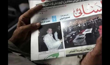 An Egyptian holds al Ahram newspaper in Cairo, fronted Mohammad Badie, the spiritual leader of Muslim Brotherhood while he is arrested on early Tuesday.