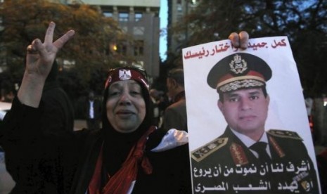 An Egyptian holds an image of Egypt's Army Chief General Abdel Fattah al-Sisi during a protest outside the Qatari Embassy in Cairo December 6, 2013.