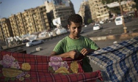 An Egyptian man builds his tent at Tahrir Square where a few protesters have built their camp protesting against the release of Egypt's ousted President Hosni Mubarak in Cairo, Egypt, Saturday, Aug. 24, 2013. Meanwhile Indonesia says it has no plan to evac