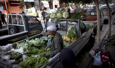 An Egyptian street vendor sits at the back of a pickup truck along with vegetables displayed for sale, in Cairo, Egypt, Thursday, Jan. 3, 2013. 