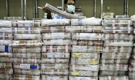 An employee of a bank stacks packets of Indonesian rupiah banknotes at a bank in Jakarta. (file photo)