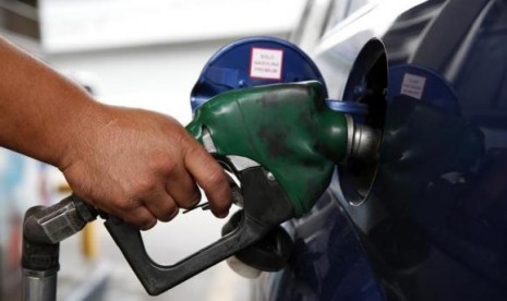 An employee pumps gas into a car at a gas station of the state oil company PDVSA in Caracas December 16, 2013. 