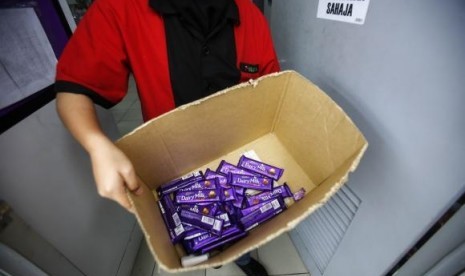 An employee shows a box containing Cadbury Dairy Milk Hazelnut and Cadbury Dairy Milk Roast Almond, to be return tomorrow in a shop in Shah Alam, outside Kuala Lumpur May 27, 2014.