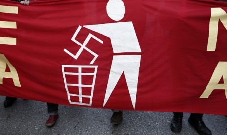 An immigrant holds a banner during an anti-racism rally in Athens January 19, 2013. 