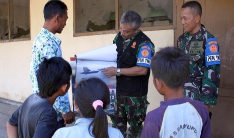 An Indonesian military officer explains about airplane to some students. In Puncak jaya, Papua, military personnel also engage in educational activities. (illustration)