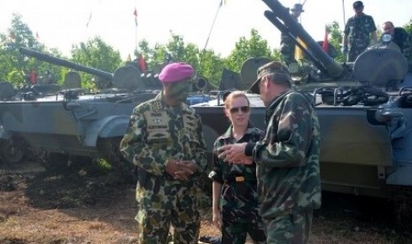 An Indonesian navy and Russian technicians have a discussion while Russian amphibious tanks park in the background in Situbondo, East Java, on Monday, Jan. 27, 2014.